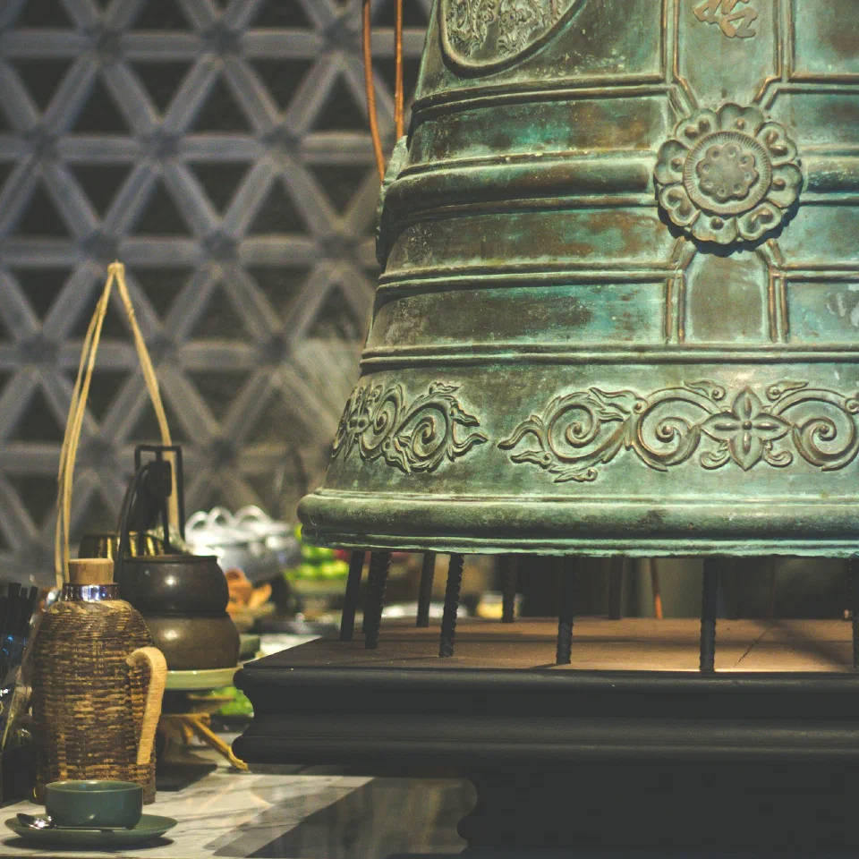 A large brass temple bell in a workshop