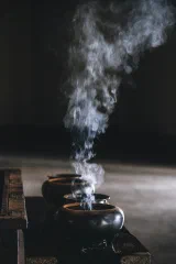 Smoke curling from an incense burner in the dark