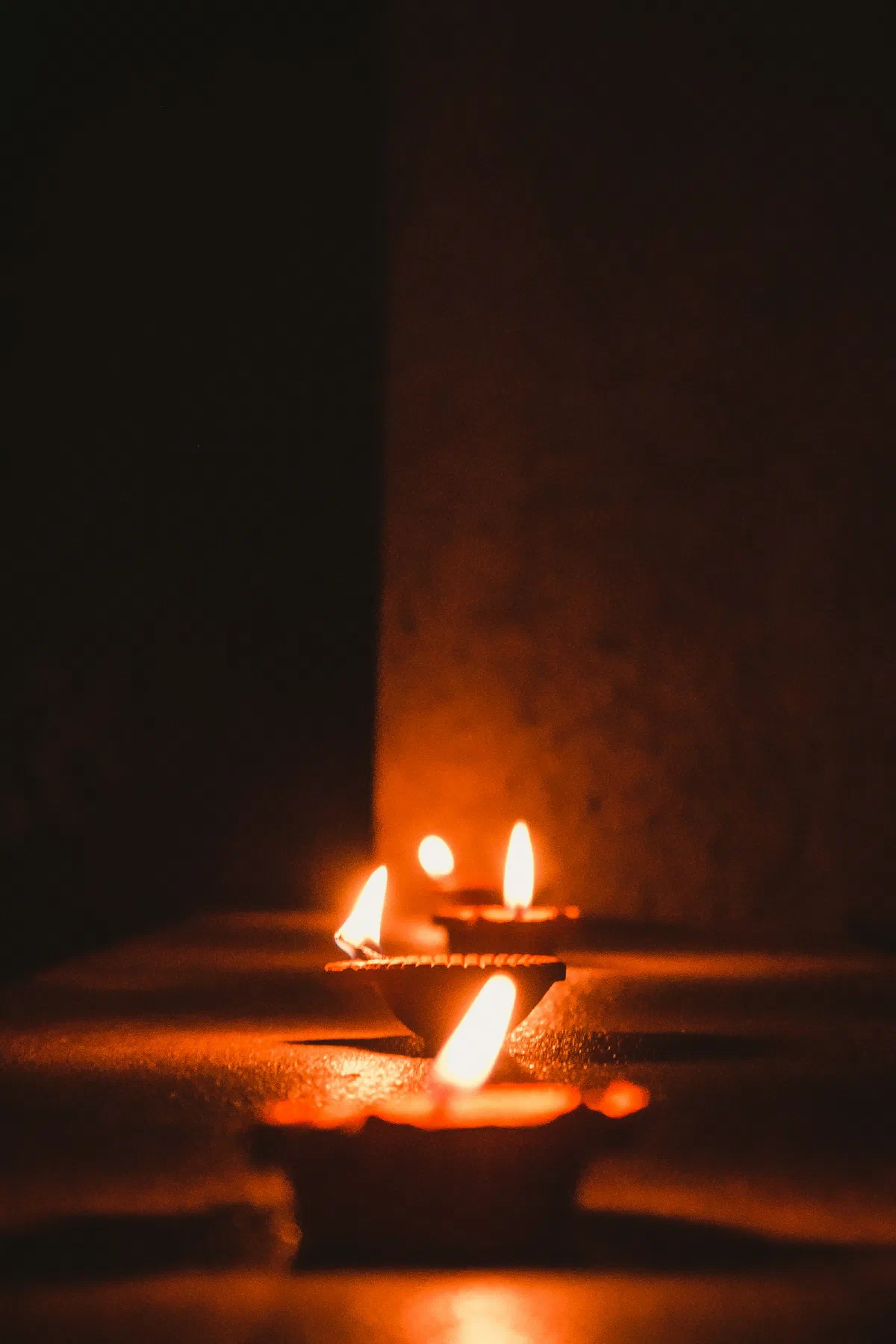 A row of lit brass oil lamps