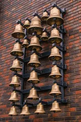 A row of brass bells mounted on a wall