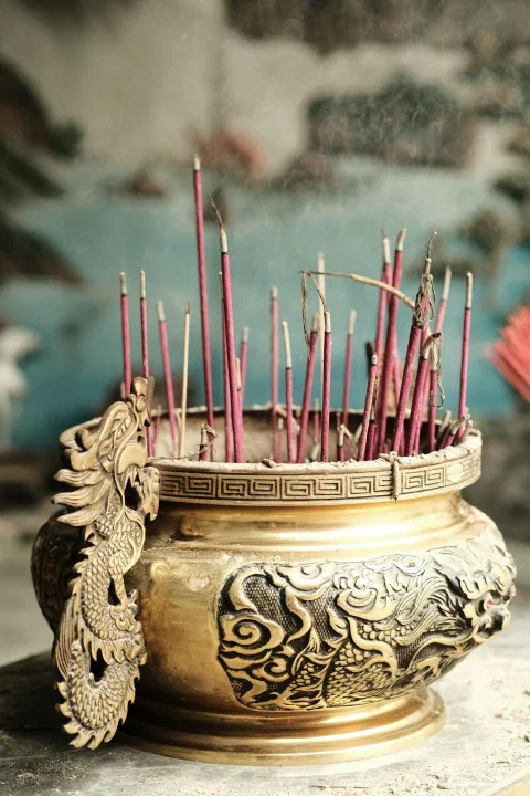 Incense sticks burning in an ornate brass holder